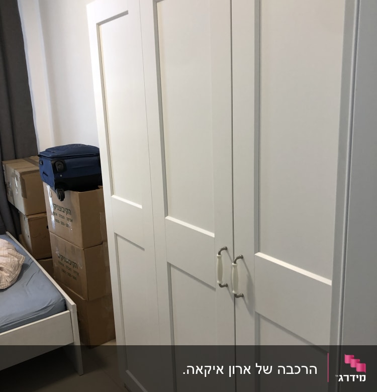 ארון לבן עם ידיות מתכת בחדר שינה